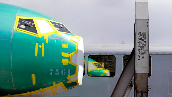 In this April 9, 2019, file photo the front of a Boeing 737 fuselage, eventually bound for Boeing's production facility in nearby Renton, Wash., sits on a flatcar rail car and is reflected in a nearby passenger train car at a rail yard in Seattle. Boeing said Tuesday, Oct. 8, that it delivered just 26 planes in September, down from 87 a year earlier, when it was ramping up Max production.