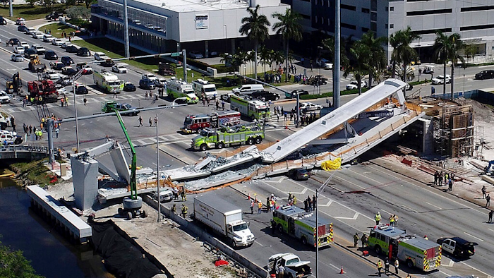 In this March 15, 2018, file photo, emergency personnel respond after a brand-new pedestrian bridge collapsed onto a highway at Florida International University in Miami. Federal officials have determined the Miami university bridge that collapsed and killed six people showed significant design errors and the state government should have conducted greater oversight because of the project’s complexity. National Transportation Safety Board members concluded Tuesday, Oct. 22, 2019, the design firm FIGG Bridge Engineers, Inc. underestimated the load of the bridge and overestimated its strength in a critical section that splintered, dropping a 174-foot-long (53-meter) span onto eight cars.