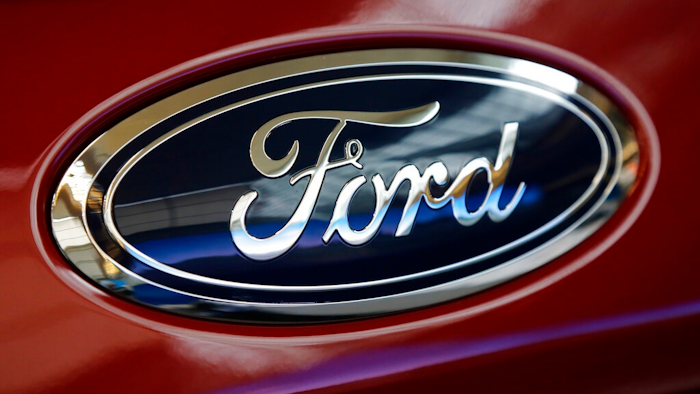 This Feb. 15, 2018, photo shows a Ford logo on a 2018 Expedition 4x4 on display at the Pittsburgh Auto Show. Ford says that next year it will start equipping redesigned models to get software updates over the internet or cellular phone connections. The company says all of its models will get the feature as they are redesigned. It will reduce visits to dealers for service and even computer-related recall repairs. Owners will be able to opt in to the program and get updates over their home wireless network at no cost. The cost for cellular updates has not been announced.