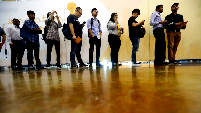 In this Sept. 17, 2019, photo job seekers line up to speak to recruiters during an Amazon job fair in Dallas. On Friday, Oct. 4, the U.S. government issues the September jobs report.