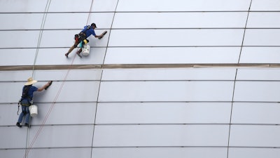 In this July 31, 2019 file photo, workers clean the outside facade of State Farm Stadium in Glendale, AZ.