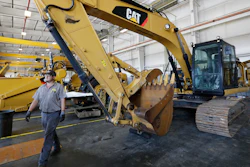 In this Sept. 18, 2019 photo, a Puckett Machinery Company technician walks past a new heavy duty Caterpillar excavator that awaits modification at Puckett Machinery Company in Flowood, MS.