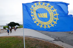 In this Sept. 30 photo, a UAW flag flies near strikers outside the General Motors Orion Assembly plant in Orion Township, MI.