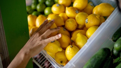 In this Aug. 21, 2019 photo, a worker stocks a produce stand at a metro station in Atlanta.