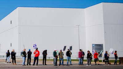 General Motors' Flint Assembly Plant employees line the street with picket signs during the nationwide UAW strike against General Motors on Monday, Oct. 7 in Flint, MI.