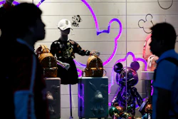 Passengers walk by merchandise on display at the Shanghai Disney flagship store at Hongqiao Railway Station in Shanghai, China, on Monday, Oct. 14.