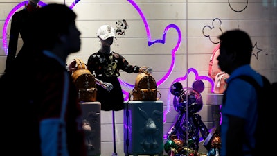 Passengers walk by merchandise on display at the Shanghai Disney flagship store at Hongqiao Railway Station in Shanghai, China, on Monday, Oct. 14.