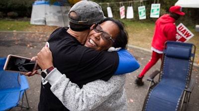 Picketing United Auto Workers Richard Rivera, left, and Robin Pinkney react to news of a tentative contract agreement with General Motors, in Langhorne, PA, on Wednesday.