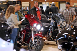 In this Oct. 17, 2019 file photo customers look over Harley Davidson motorcycles on display at a dealership in Ashland, VA.