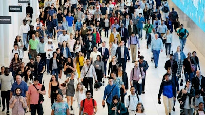 In this June 21, 2019 file photo, commuters walk through a corridor in the World Trade Center Transportation Hub in New York.