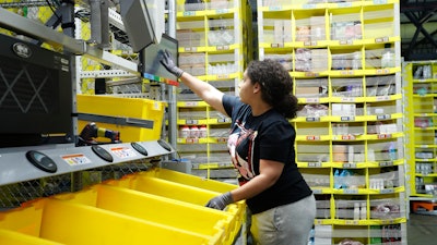 In this June 26, 2019 file photo, a worker sorts through items and places orders at the Amazon Fulfillment Center in Staten Island in New York.