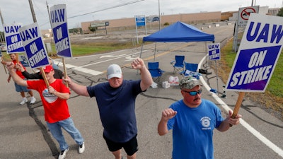 In this Sept. 16 file photo, picketers carry signs at one of the gates outside the closed General Motors automobile assembly plant in Lordstown, OH.
