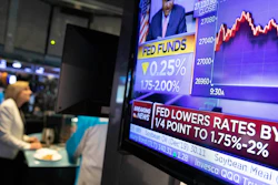 In this Sept. 18, 2019 file photo, a television monitor at the New York Stock Exchange carries the news after the Federal Reserve made its interest rate announcement.