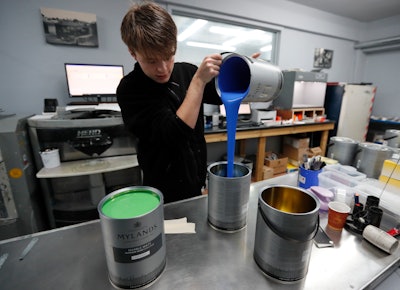 Harvey Myland prepares paint for mixing at the factory in London on Thursday, Oct. 24.