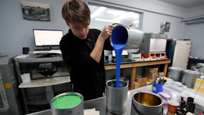 Harvey Myland prepares paint for mixing at the factory in London on Thursday, Oct. 24.