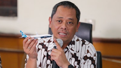 National Transportation Safety Committee investigator Nurcahyo Utomo holds a model of an airplane during a press conference in Jakarta, Indonesia. An Indonesian investigation found a Lion Air flight that crashed and killed 189 people a year ago was doomed by a combination of aircraft design flaws, inadequate training and maintenance problems.