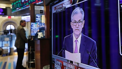In this June 19, 2019 file photo, the Washington news conference of Federal Reserve Chair Jerome Powell appears on television screen on the trading floor of the New York Stock Exchange shows the rate decision of the Federal Reserve.