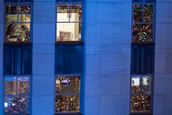 In this Nov. 28, 2018 file photo, people work in their office after the Rockefeller Center Christmas tree is lit during the 86th annual Rockefeller Center Christmas tree lighting ceremony in New York.