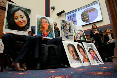 People holding photos of those lost in Ethiopian Airlines Flight 302 and Lion Air Flight 610 listen during a House Transportation and Infrastructure Committee hearing with Boeing executives, Wednesday, Oct. 30 on Capitol Hill in Washington.
