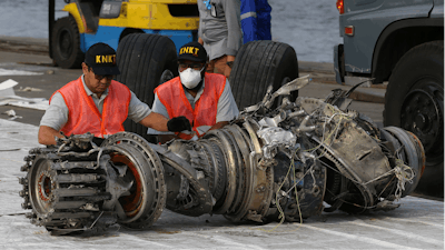 In this file photo officials inspect an engine recovered from the crashed Lion Air jet in Jakarta, Indonesia. On the anniversary of the first crash of a Boeing 737 Max, the CEO will begin two days of testimony before Congress.