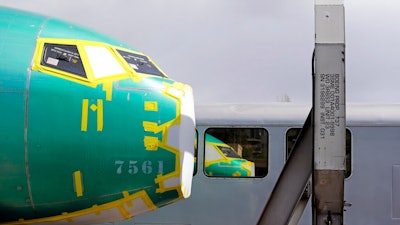 In this April 9, 2019, file photo the front of a Boeing 737 fuselage, eventually bound for Boeing's production facility in nearby Renton, Wash., sits on a flatcar rail car and is reflected in a nearby passenger train car at a rail yard in Seattle. Boeing said Tuesday, Oct. 8, that it delivered just 26 planes in September, down from 87 a year earlier, when it was ramping up Max production.