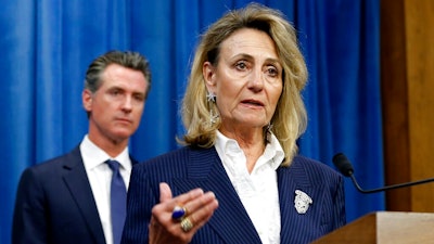 In this July 23, 2019, file photo, Marybel Batjer, of the California Public Utilities Commission, speaks during a news conference as Gov. Gavin Newsom looks on in Sacramento, Calif. California's utility regulator is issuing a series of sanctions against Pacific Gas and Electric for what it calls 'failures in execution' during the largest planned power shut-off in state history to avoid wildfires. Batjer said Monday, Oct. 14, 2019, the utility needs to have a goal of restoring power within 12 hours instead of its current 48 hours, minimize the scale of future outages and better communicate with the public and local officials.
