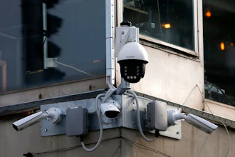 In this photo taken Sept. 25, 2019, high-tech video cameras hang from an office building in downtown Belgrade, Serbia. The cameras, equipped with facial recognition technology, are being rolled out across hundreds of cities around the world, particularly in poorer countries with weak track records on human rights where Beijing has increased its influence through big business deals.