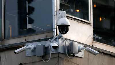 In this photo taken Sept. 25, 2019, high-tech video cameras hang from an office building in downtown Belgrade, Serbia. The cameras, equipped with facial recognition technology, are being rolled out across hundreds of cities around the world, particularly in poorer countries with weak track records on human rights where Beijing has increased its influence through big business deals.