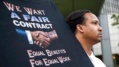 Sean Crawford, of United Auto Workers 598, rallies outside the Marriott Renaissance Hotel while the UAW GM Council holds a meeting inside the hotel in Detroit, Sunday Sept. 15, 2019. The new four-year deal between General Motors and 49,000 United Auto Workers will drive up the company’s expenses with pay raises, bonuses and other increases. But analysts say GM is far better able to handle the expenses now than it was a decade ago, when the high cost of labor helped send it into bankruptcy protection.