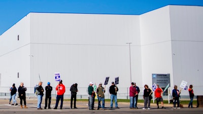 General Motors' Flint Assembly Plant employees line the street with picket signs during the nationwide UAW strike against General Motors on Monday, Oct. 7, 2019, in Flint, Mich.