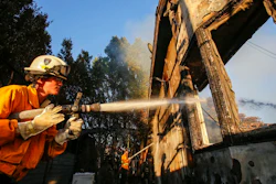 Firefighters work on a house destroyed by a wildfire called the Getty Fire in Los Angeles, Monday, Oct. 28, 2019.