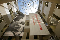 In this July 30, 2013, file photo, large banners hang in an atrium at the headquarters of Johnson & Johnson in New Brunswick, N.J. Johnson & Johnson has become the latest company to settle a lawsuit to get out of the first federal trial over the nation's opioids crisis, reaching a deal worth more than $20 million with two Ohio counties, the company announced Tuesday, Oct. 1, 2019.