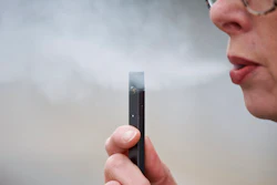 In this April 16, 2019, file photo, a woman exhales a puff of vapor from a Juul pen in Vancouver, Wash. A former Juul Labs executive is alleging that the vaping company knowingly shipped 1 million tainted nicotine pods to customers. The allegation comes in a lawsuit filed Tuesday, Oct. 29, by a former finance executive who was fired by the vaping giant earlier this year.