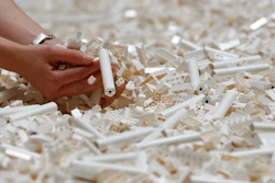 In this Friday July 26, 2019, file photo, a visitor looks through Lego pieces provided for a project at the Tate Modern, in London. Lego is testing a way for customers to ship their unwanted bricks back and get them into the hands of other kids.