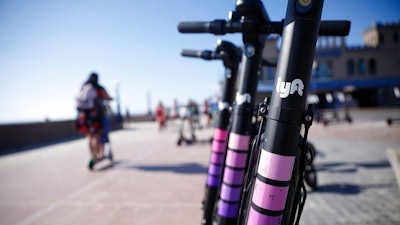 In this May 28, 2019, file photo Lyft scooters are seen along Mission Beach boardwalk in San Diego. Lyft, Inc. reports financial earns on Wednesday, Oct. 30.