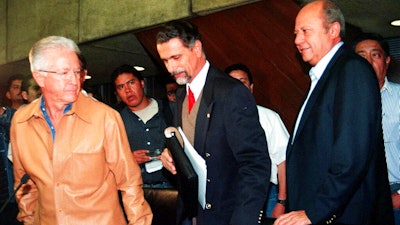 In this Sept. 29, 2000 file photo, leader of Mexico’s oil workers union Carlos Romero Deschamps, right, Labor Secretary Carlos Maria Abascal, center, and Pemex director Raul Munoz Leos, arrive to a media conference in Mexico City. Several Mexican news media are reporting the resignation of Romero Deschamps, who has been in the job since 1993. El Universal says the union of Pemex workers will issue a statement later Wednesday, Oct. 16, 2019.