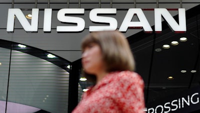 In this July 25, 2019, file photo, a pedestrian walks past a Nissan car gallery in Tokyo. Japanese automaker Nissan Motor Co. has named the head of its China business, Makoto Uchida, to be its new CEO.