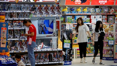 In this May 23, 2019, file photo, customers shop near a section selling Marvel Avengers toys by American toymaker Hasbro at a toy store in Beijing. The nation's business economists think President Donald Trump's trade war with China will contribute to a sharp slowdown in economic growth this year and next, raising concerns about a possible recession starting late next year.