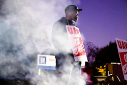 In this Sept. 27, 2019, file photo worker Omar Glover pickets outside a General Motors facility in Langhorne, Pa. A tentative four year contract with striking General Motors gives workers a mix of pay raises, lump sum payments and an $11,000 signing bonus.