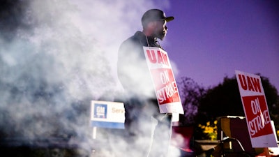 In this Sept. 27, 2019, file photo worker Omar Glover pickets outside a General Motors facility in Langhorne, Pa. A tentative four year contract with striking General Motors gives workers a mix of pay raises, lump sum payments and an $11,000 signing bonus.