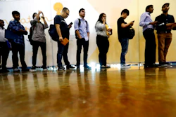 In this Sept. 17, 2019, photo job seekers line up to speak to recruiters during an Amazon job fair in Dallas. On Friday, Oct. 4, the U.S. government issues the September jobs report.