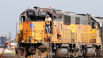 In this July 20, 2017, file photo, a Union Pacific Railroad Company employee stands on a locomotive in Council Bluffs, Iowa. More than two dozen major companies ranging from Campbell Soup to Kia filed anti-trust lawsuits on Sept. 30, 2019 against the nation's four largest railway companies, contending the railroads had a price-fixing scheme to illegally boost profits.