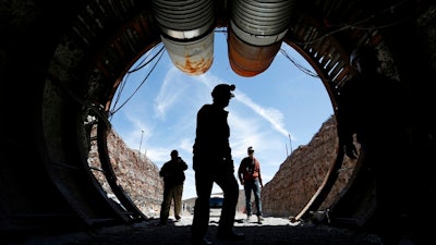 In this April 9, 2015, file photo, people walk into the south portal of Yucca Mountain during a congressional tour of the proposed radioactive waste dump near Mercury, Nev., 90 miles northwest of Las Vegas. A federal judge in Reno has agreed to allow Nevada to amend its lawsuit in an ongoing legal battle with the U.S. Energy Department to try to show why the government should be forced to remove weapons-grade plutonium it secretly shipped to a site near Las Vegas last year over the state's objections.