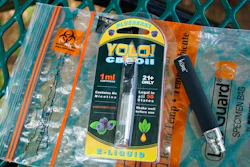 In this May 8, 2019, file photo, a Yolo! brand CBD oil vape cartridge sits alongside a vape pen on a biohazard bag on a table at a park in Ninety Six, S.C. More than 50 people around Salt Lake City had been poisoned by the time the outbreak ended early last year, most by a vape called Yolo!, the acronym for 'you only live once.'