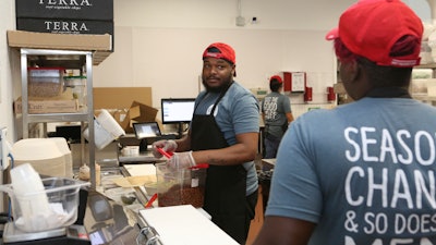 Workers in the B.Good ghost kitchen inside Kitchen United's Chicago location prepare food for delivery.