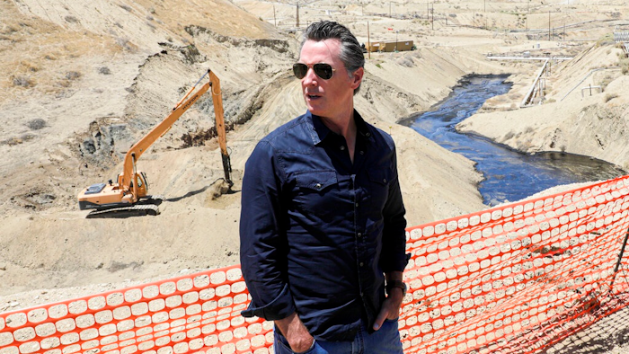 In this July 24, 2019, file photo, Gov. Gavin Newsom tours the Chevron oil field west of Bakersfield where a spill of more than 800,000 gallons flowed into a dry creek bed in McKittrick, Calif. Newsom's administration has temporarily banned new oil wells in California if they use an extraction method that is linked to an ongoing oil spill in Kern County. On Tuesday, Nov. 19, 2019, the Division of Oil, Gas and Geothermal Resources announced it will not approve new oil wells that use high-pressure steam to soften the thick crude underground so it can flow more easily.