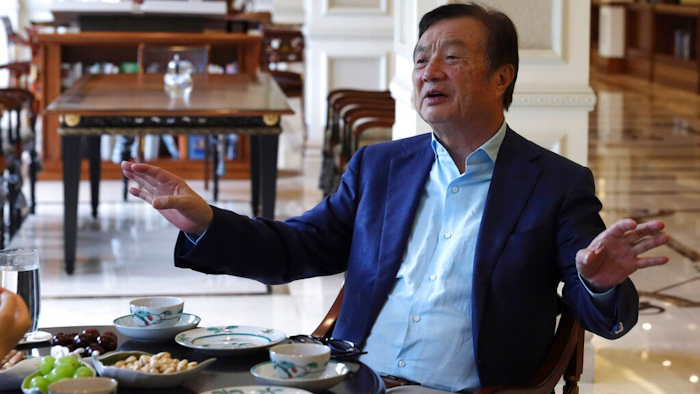In this Aug. 20, 2019, photo, Huawei's founder Ren Zhengfei gestures as he chats with Huawei executives at the company campus in Shenzhen in Southern China's Guangdong province. Ren says its troubles with President Donald Trump are hardly the biggest crisis he has faced while working his way from rural poverty to the helm of China’s first global tech brand.