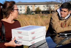 In this Saturday, Oct. 26 photo, Catherine Newton, left, buys three boxes of Krispy Kreme doughnuts from Jayson Gonzalez in Little Canada, MN.