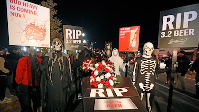 A ghoulish group of pallbearers stand in front of a casket representing 3.2% beer on Wednesday, Oct. 30 in Salt Lake City. After 86 years, this Halloween marks the last day 3.2% beer will be sold in Utah stores. Beginning Nov. 1, Utah stores will be selling up to 5% ABV beer, and Budweiser wants to celebrate with a funeral complete with their famous Clydesdales, in the background.