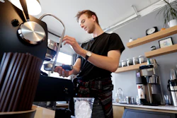 In this Nov. 4 photo, barista Porter Hahn makes an iced coffee drink for a customer in a coffee shop in Seattle.